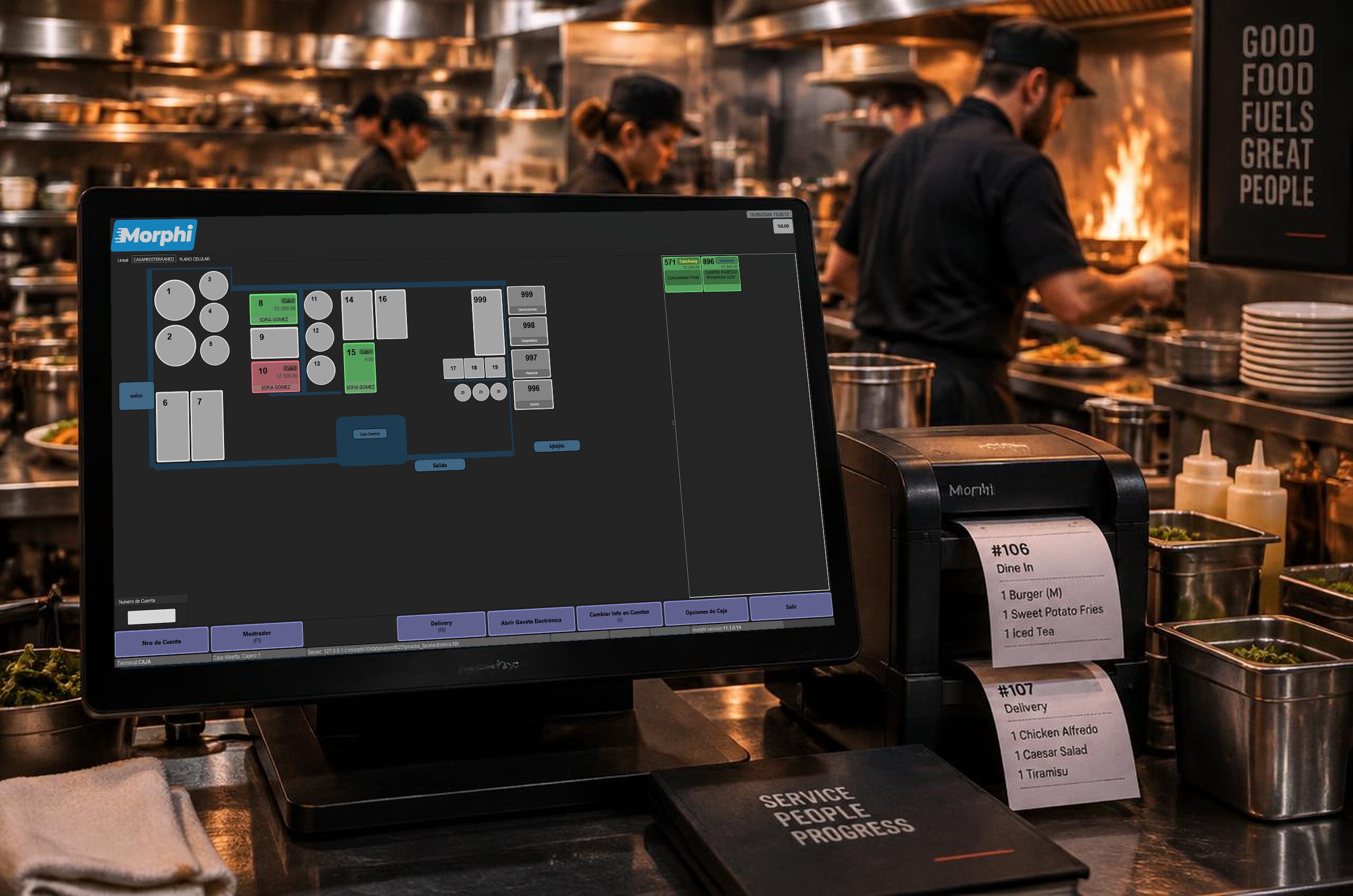 Monitor en el mostrador de una cocina mostrando la pantalla principal del POS de Morphi: plano del salón con mesas en vivo, take away y delivery